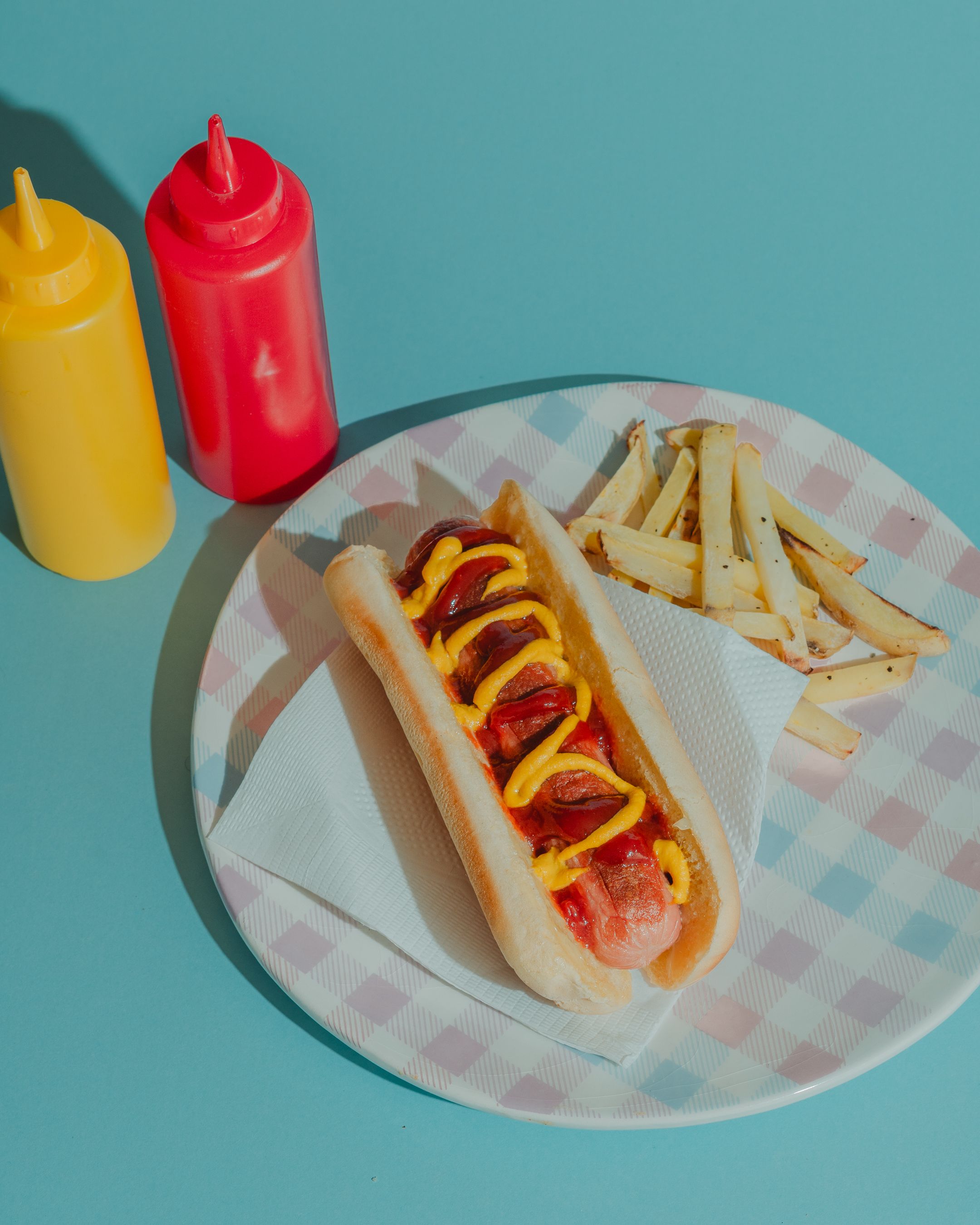 Hot dog with mustard and ketchup served with fries
